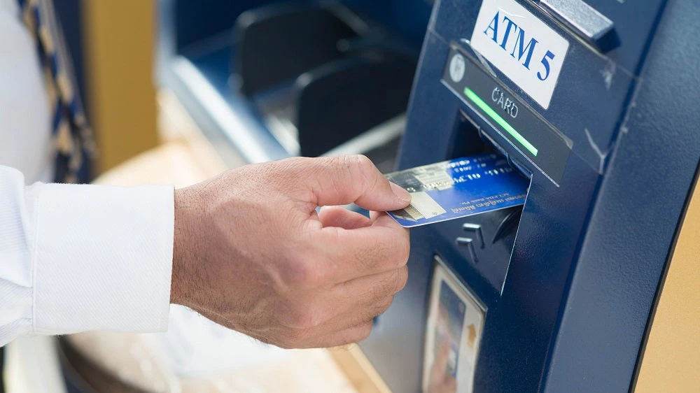 hand holding card at ATM