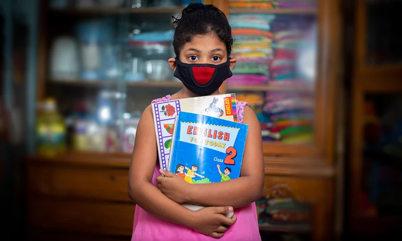 A teenage girl wearing a protective cloth mask against transmissible COVID-19 diseases and she stay his home at Dhaka.