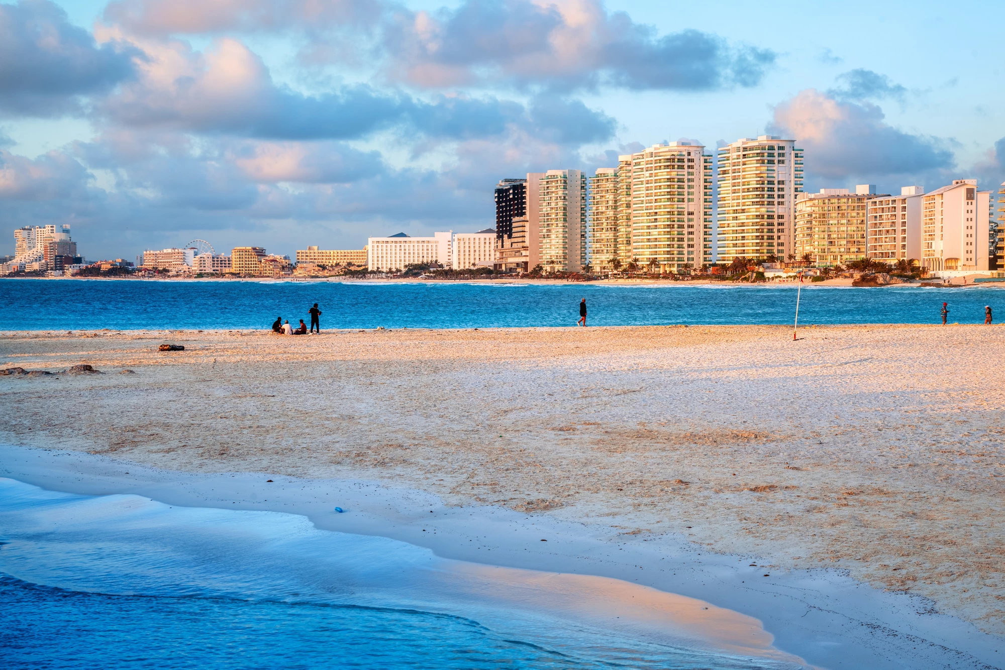Carribean sand beach in Cancun city downtown in pink sunrise light, Mexico