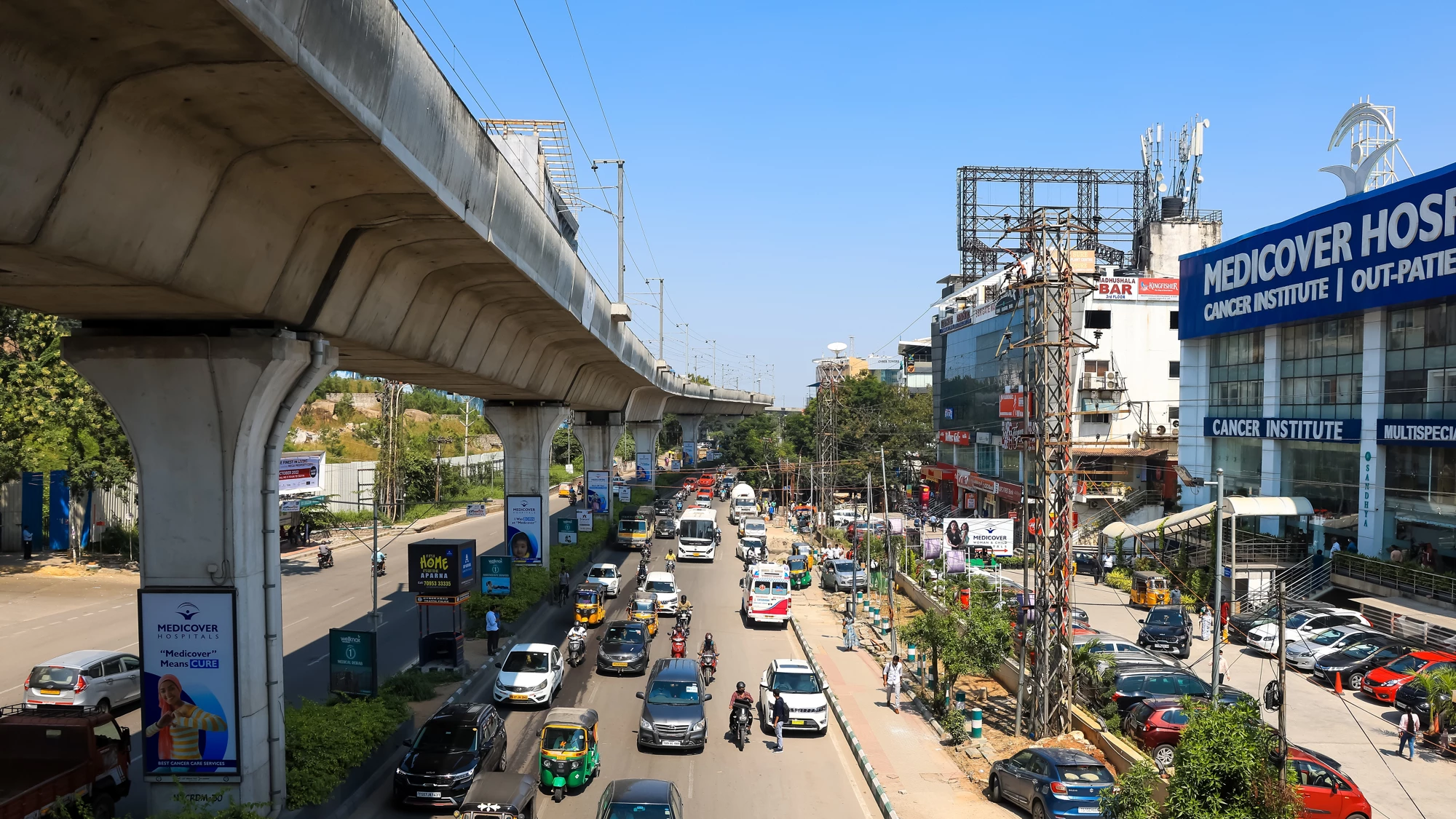 HYDERABAD, INDIA - OCTOBER 25, 2022: Busy traffic during the rush hour in the streets of Hyderabad, with many cars and two wheelers on the road along side elevated metro network.