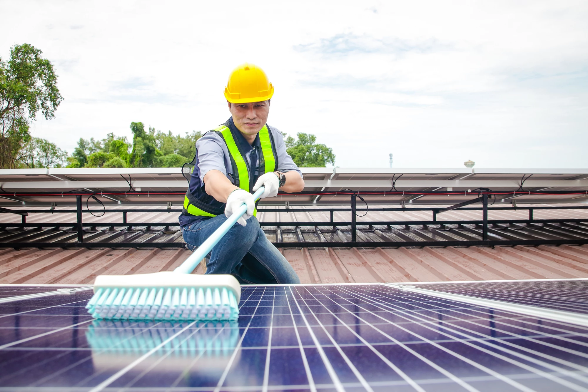 Solar panel installers use brushes to clean dust from solar panels to produce and sell electricity. energy technology concept