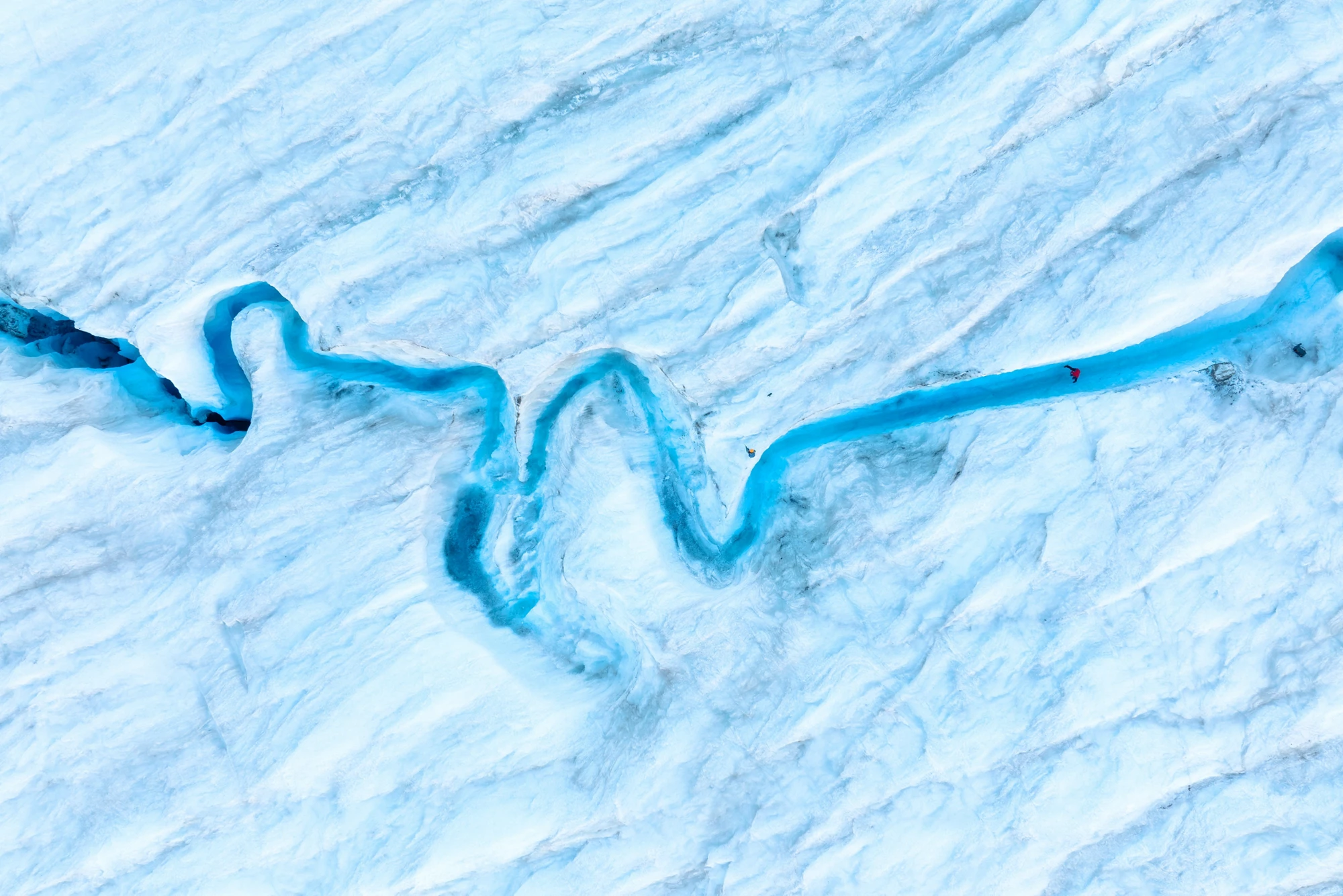 An aerial view of an iceberg and river. Winter landscape from a drone. View of the moraines. Landscape from the air. River on a moraine. 