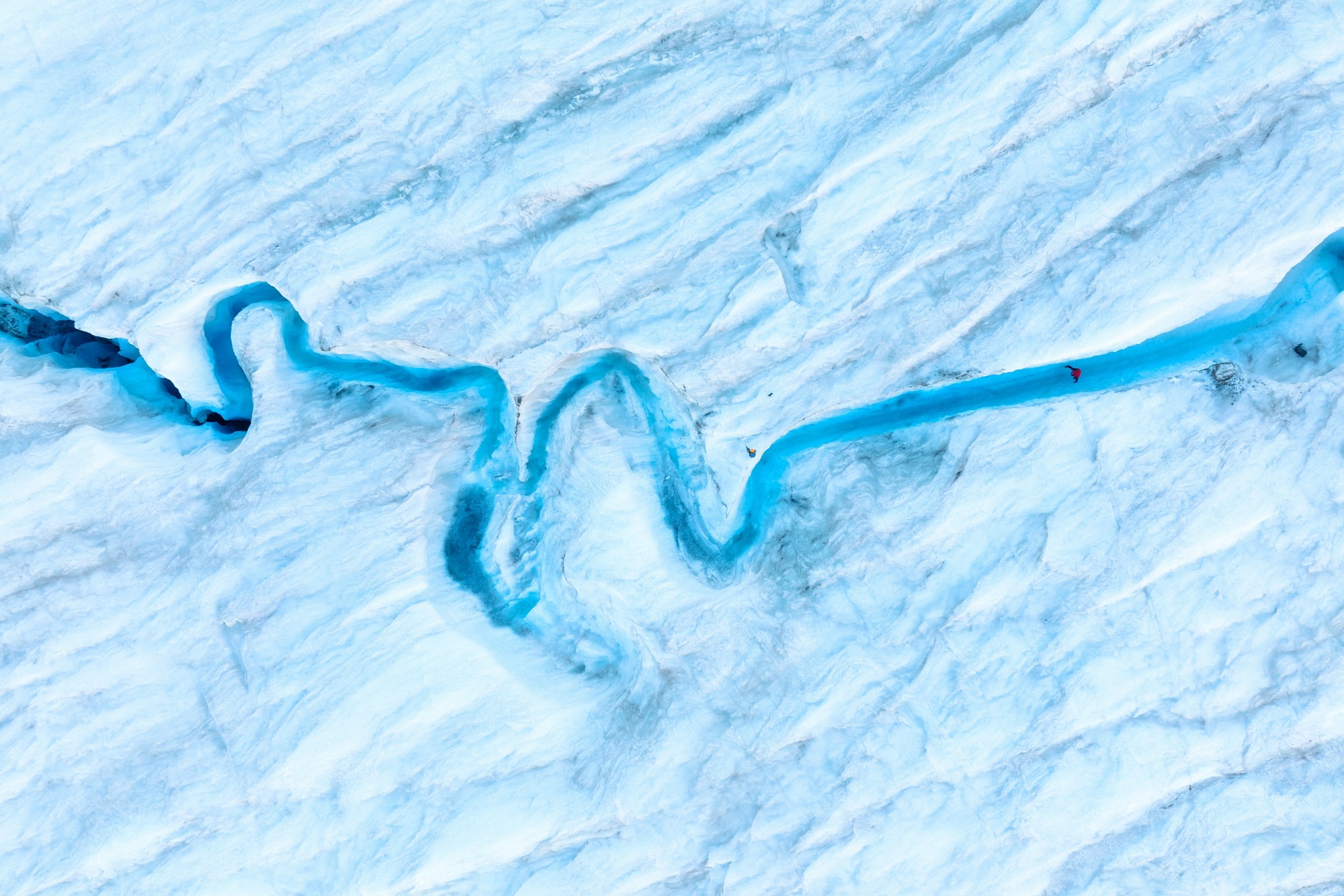 An aerial view of an iceberg and river. Winter landscape from a drone. View of the moraines. Landscape from the air. River on a moraine. 