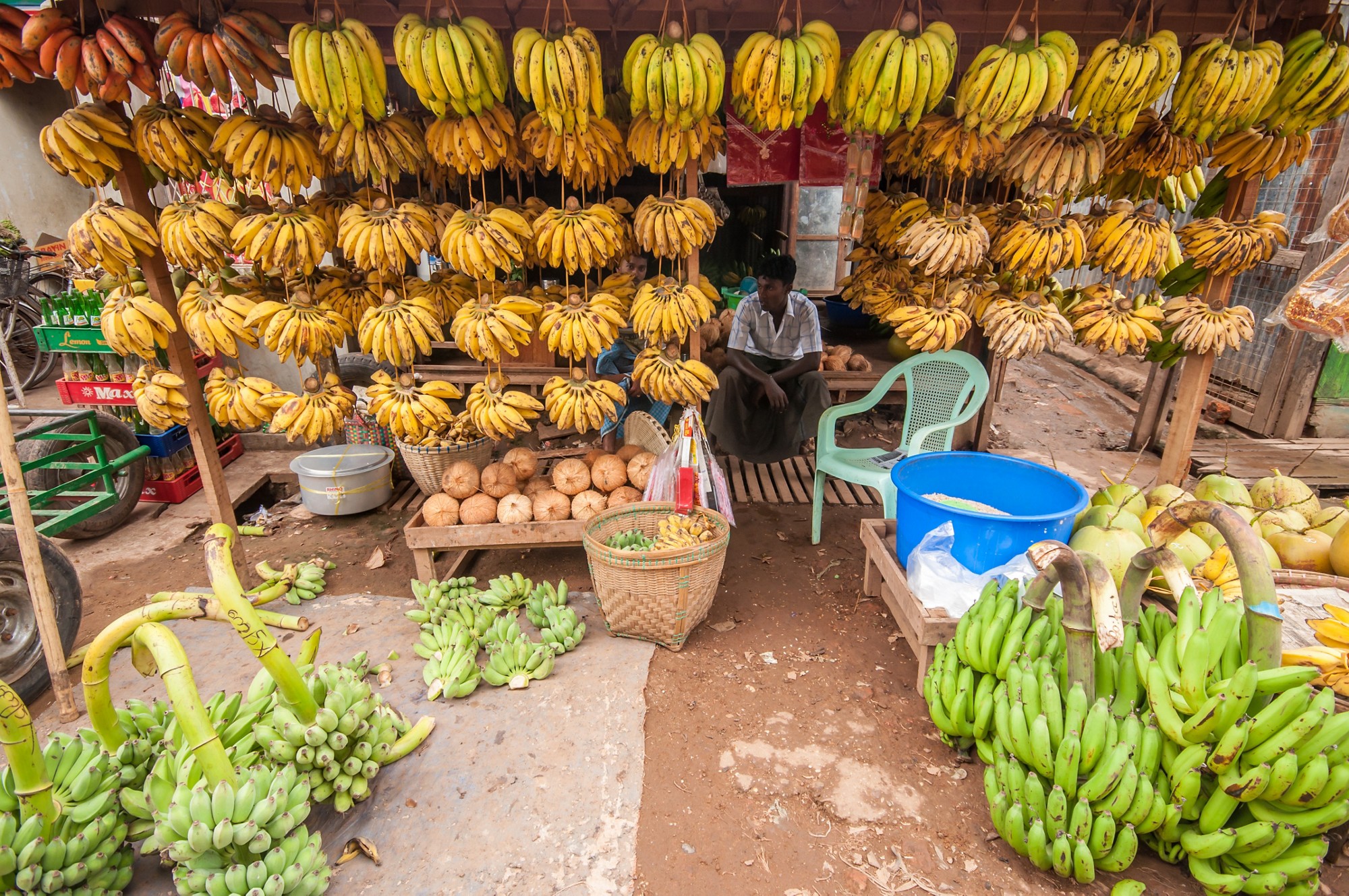 Thanlyin, Myanmar - March 14, 2011: The Myanmar vendor selling banana and coconut at street market  in Thanlyin, Myanmar.