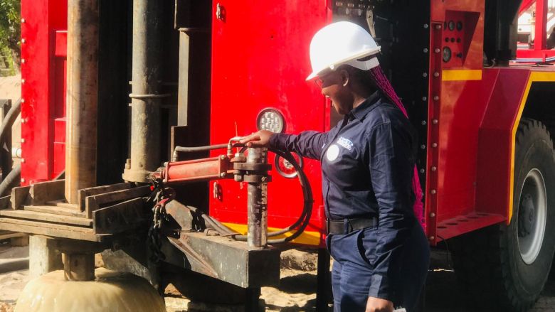 A woman operates a mud rotary drilling rig.