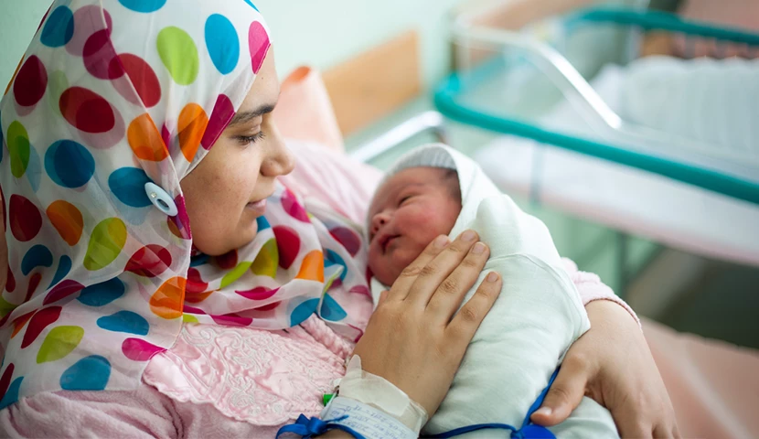 Card - Arabic Muslim mother carrying her child in hospital bed immediately after delivery.png