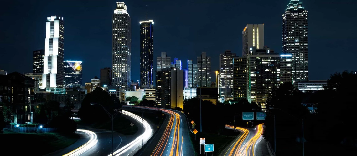 Skyscrapers and roads illuminated by a city's lights in the evening