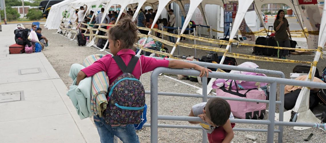 Niños y adultos esperan en puesto fronterizo 