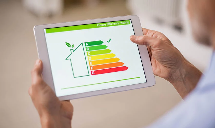 A person holding a digital tablet and looking at house efficiency rating.