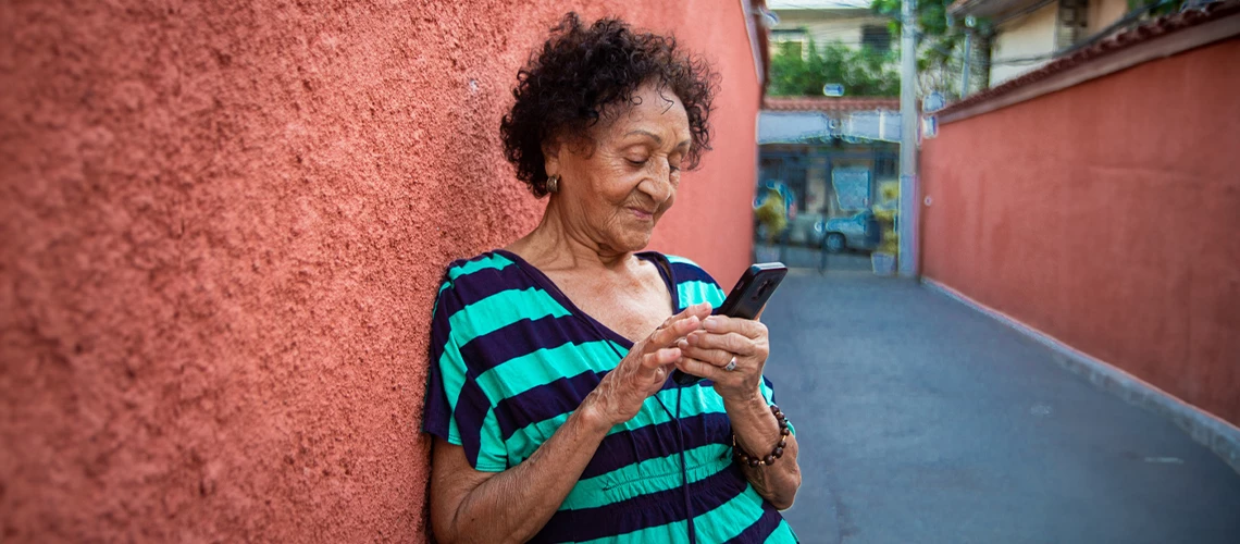 Senior brazillian woman reading a message on a smartphone