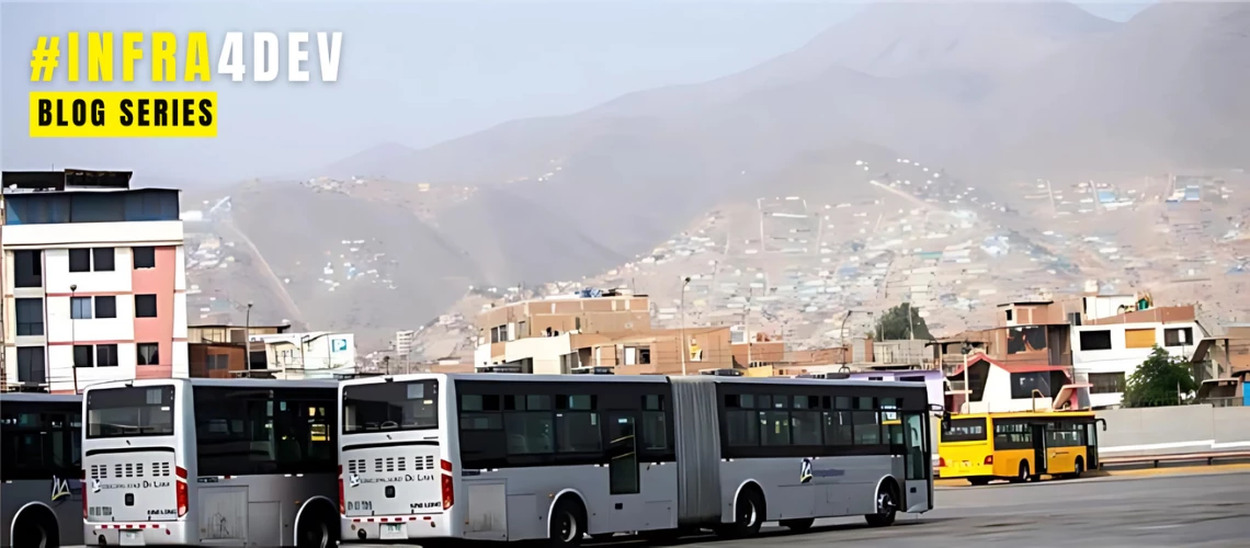 Buses parked in a parking lot facing a neighborhood built on a hill in Peru