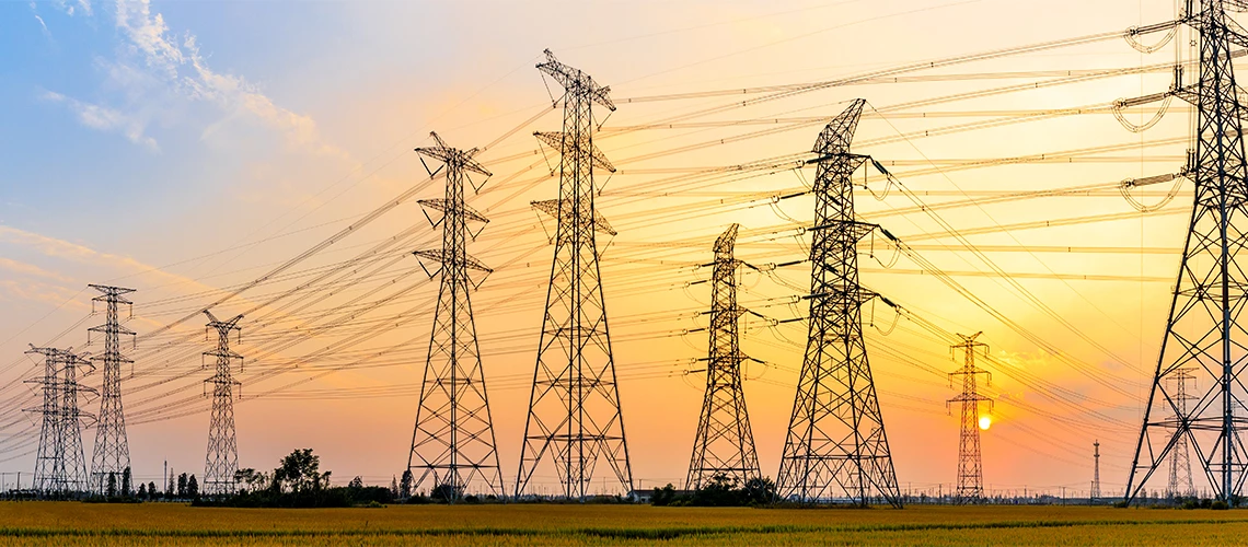 High-voltage power lines at sunset.