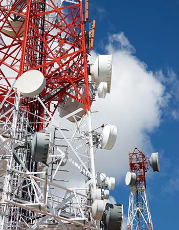 Telecommunications tower with cloudy sky.