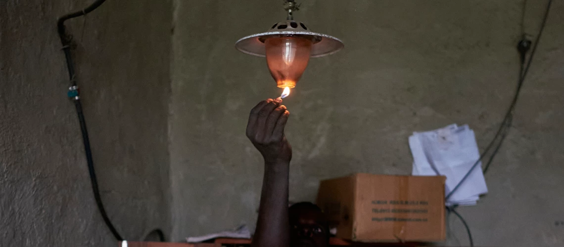 Man lighning a gas lamp in a house in Ethiopia