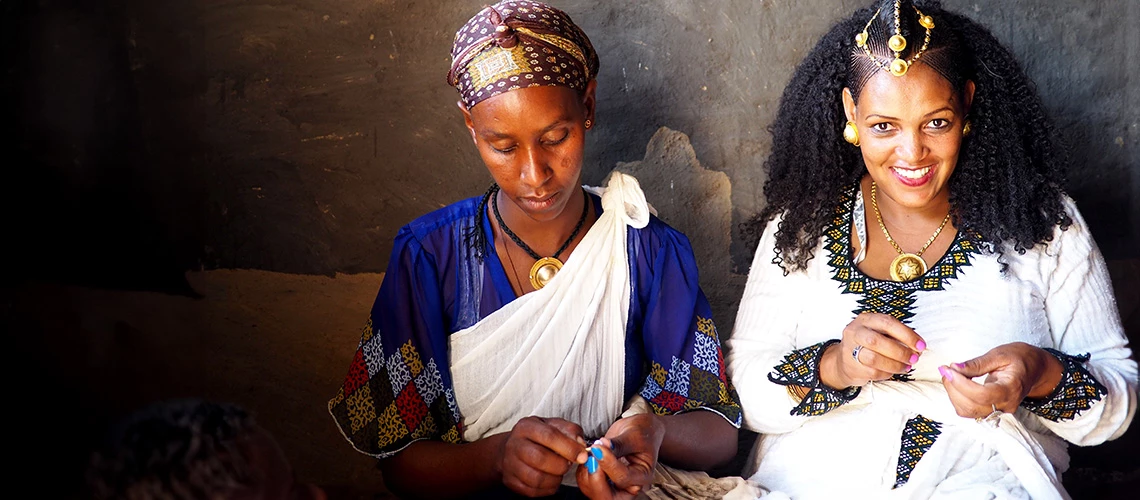 Two women work on beading a traditional Ethiopian wedding decoration. | © shutterstock.com