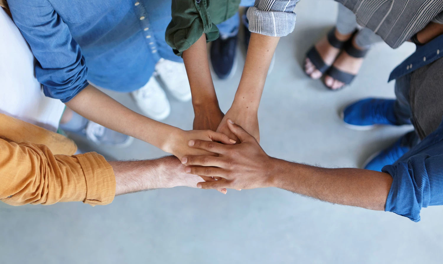 People piling their hands showing friendship, partnership, togetherness, and a collaboration concept.