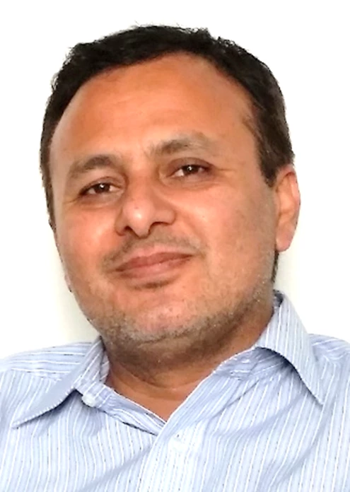 Man with dark short hair, wearing blue shirt