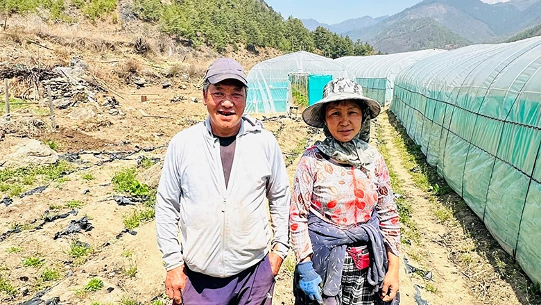 Kinley with her husband showcasing the greenhouse in her field.