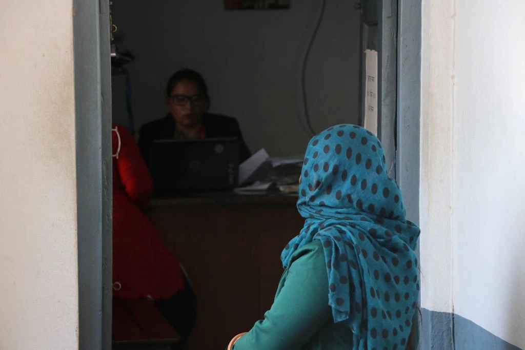 A woman sits outside the office of a woman professional at Khabar Garaun