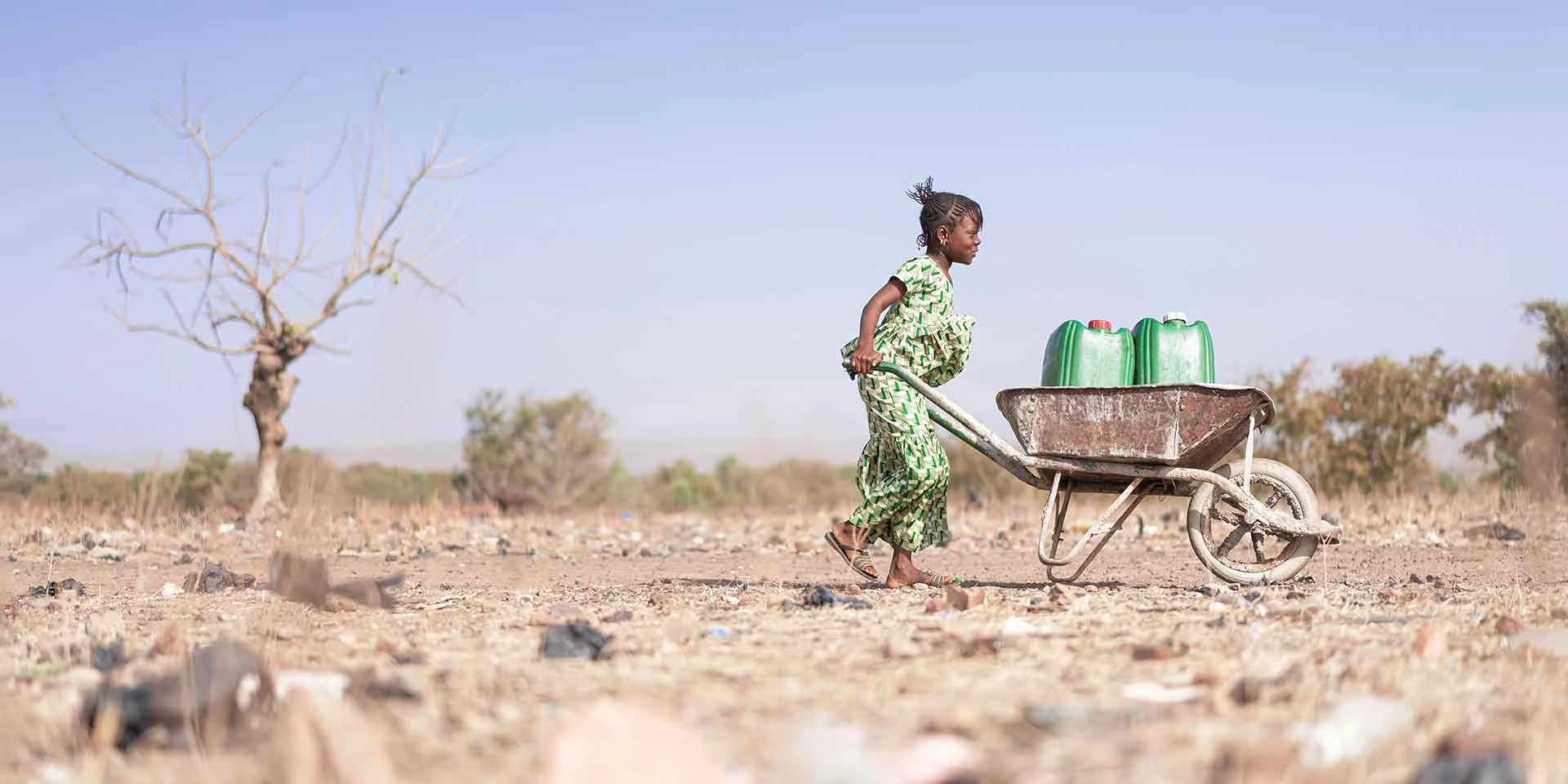 Little African Woman Transporting Fresh Water as a drought symbol