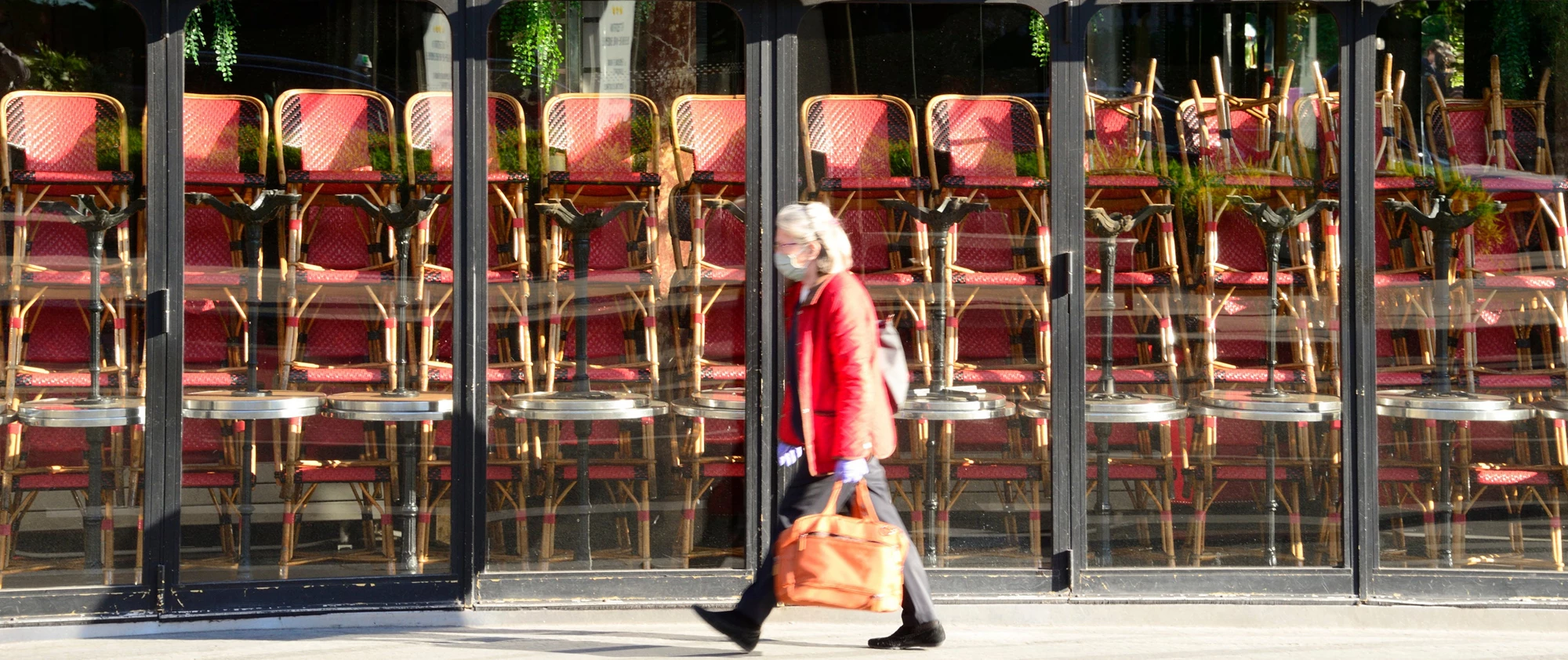 A woman wearing a mask walks in front of a restaurant closed because of covid-19. | © shutterstock.com
