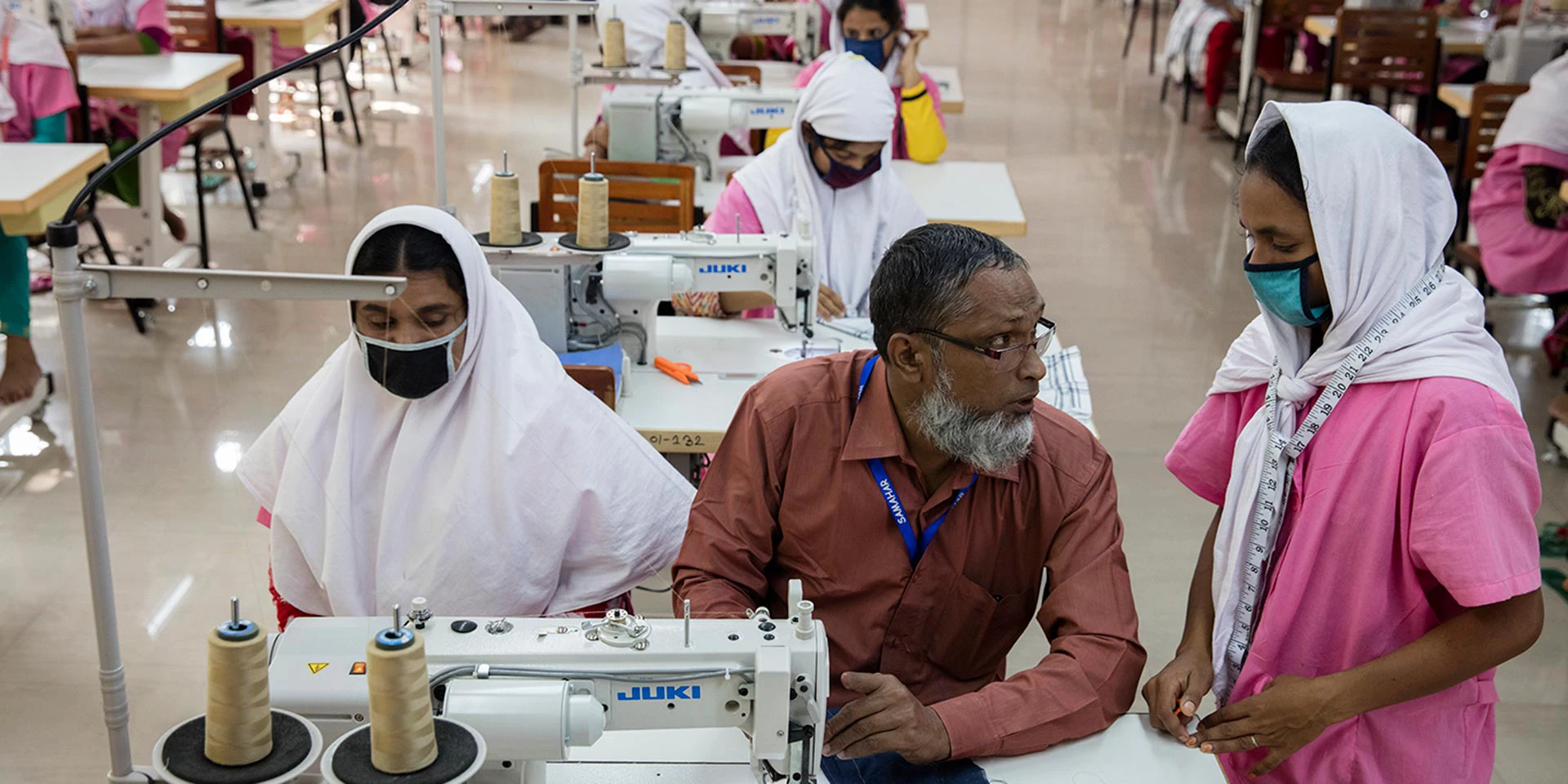 Kasam (center) helps young Bangladeshi women as they are being trained at the Savar EPZ training center in Dhaka, Bangladesh on October 13, 2016. Photo © Dominic Chavez/World Bank