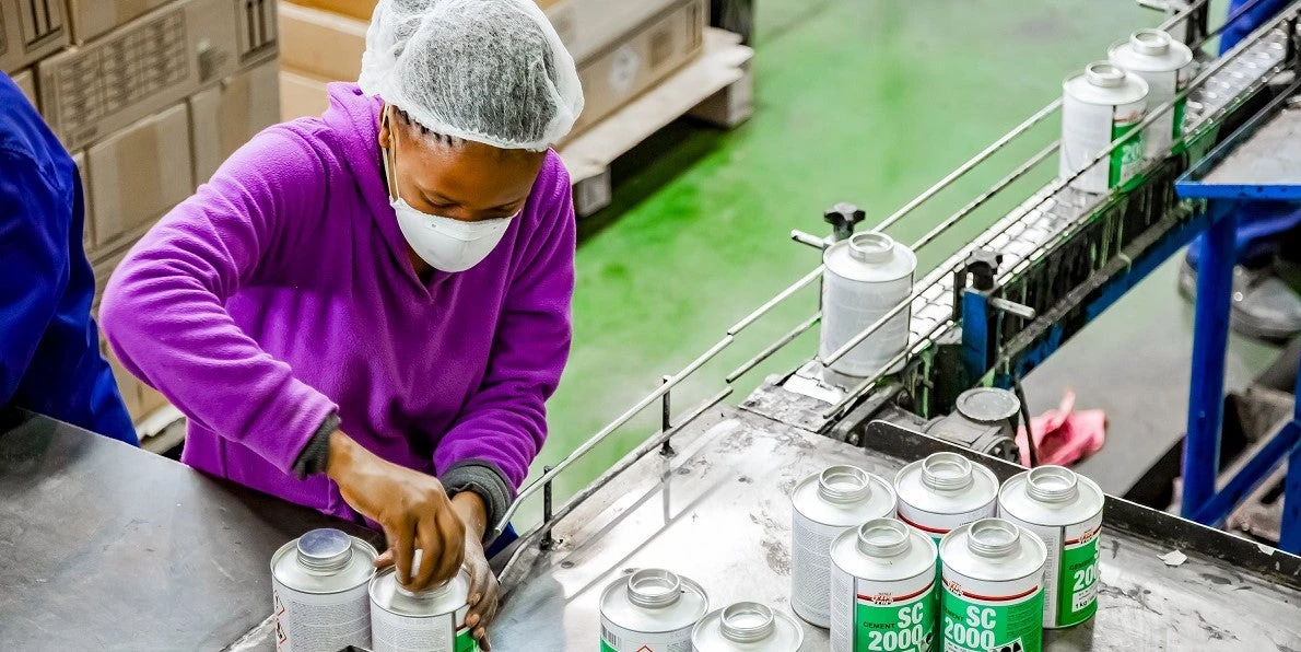  Una mujer trabaja en una cadena de producción de una fábrica de pegamento en Johannesburgo, Sudáfrica. Fotografía: © Sunshine Seeds/Shutterstock.