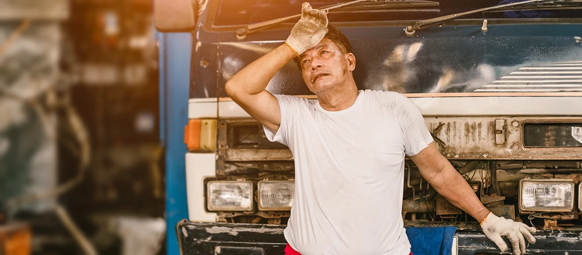 Tired and exhausted man working in garage auto service. | © shutterstock.com