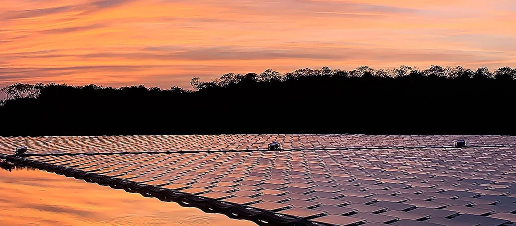 A floating solar farm on a lake at sunset.