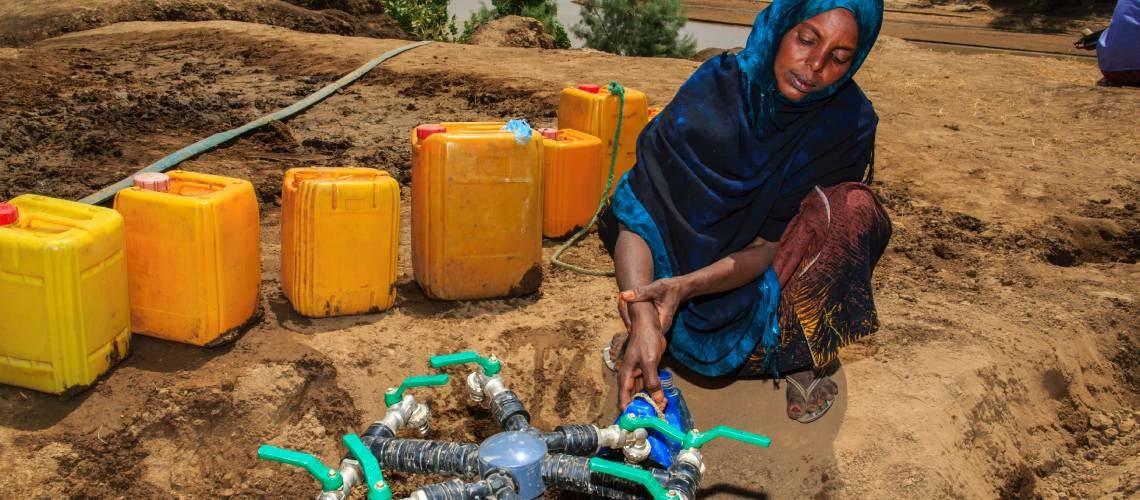 A woman collects water from a public tap in rural Ethiopia.