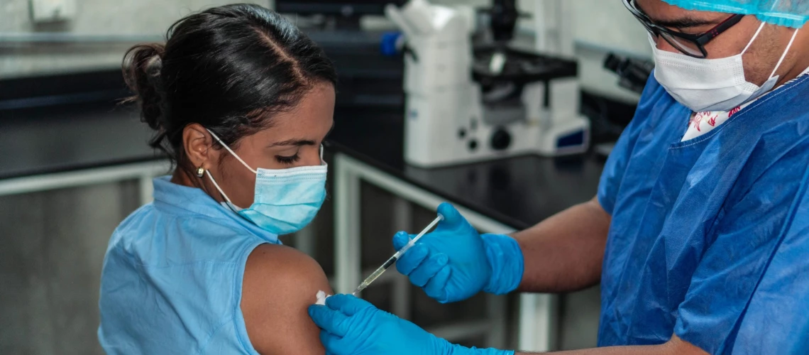 hispanic woman receiving vaccine injection in arm