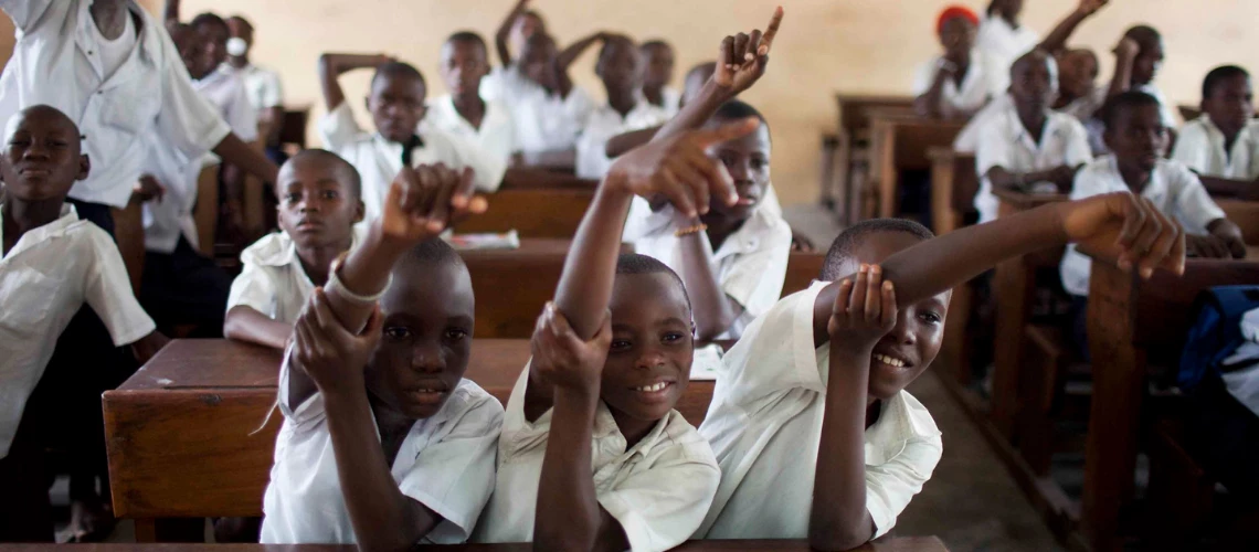 Des élèves lèvent la main pour répondre aux questions d'une classe à l'école primaire Saint-Louis de Kinshasa