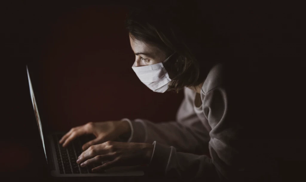 Woman in a face mask using her computer