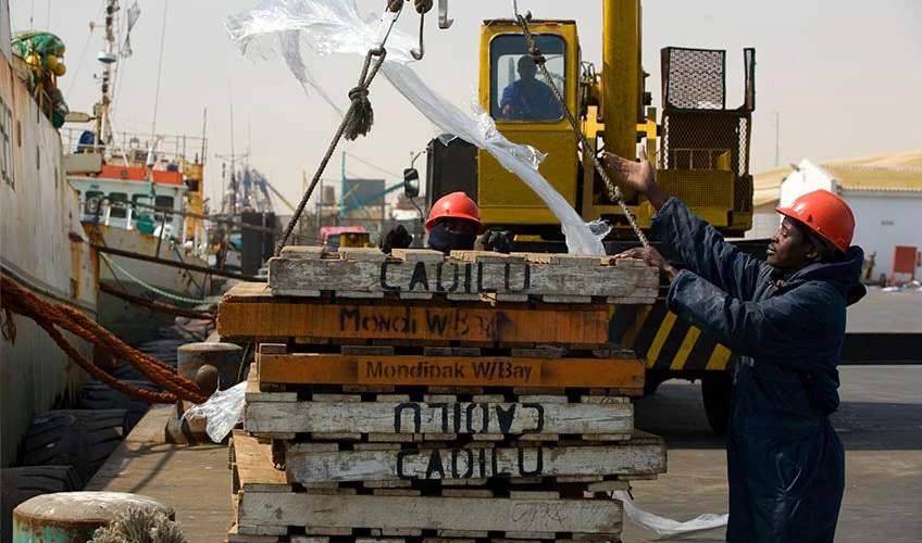 a fishing ship is loaded with clean containers for its next trip