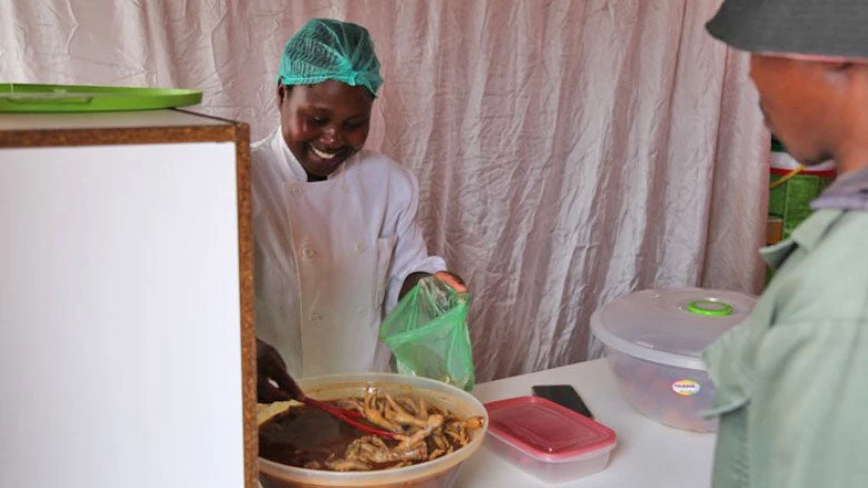 Qenehelo serves up chicken legs, fat cakes, and potato chips to her customers