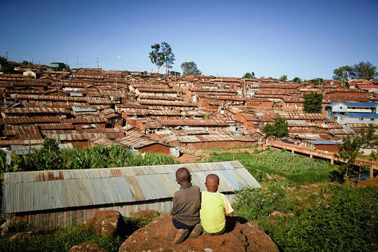 Local children sit on a boulder overlooking the Kenyan slum of Kibera @Gates Foundation 