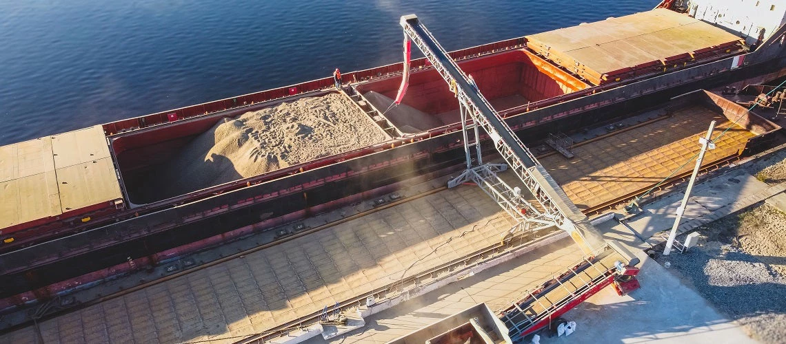 Aerial view of big grain elevators on the sea. Loading of grain on ship. Port Ukraine. Cargo ship