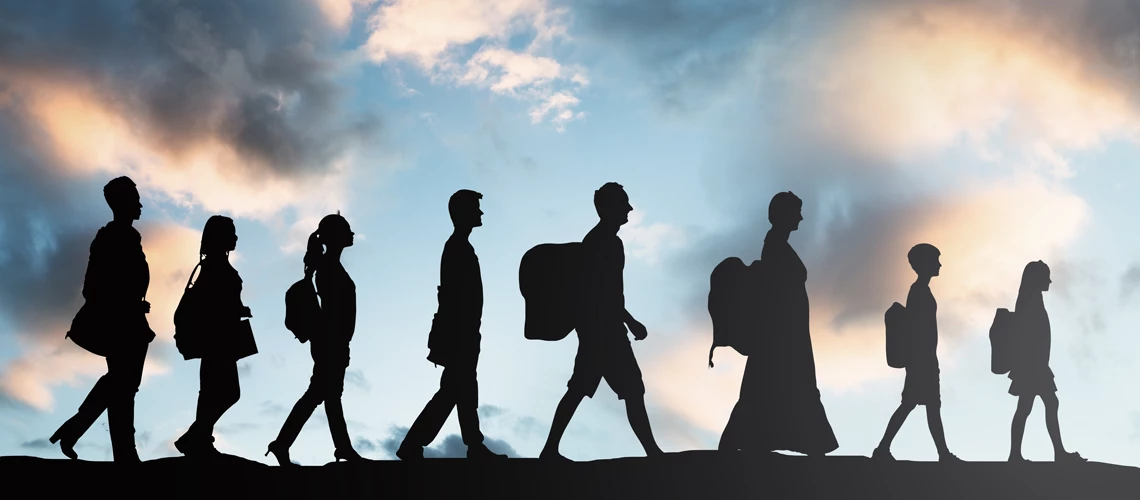 Silhouette of people with luggage walking in a row