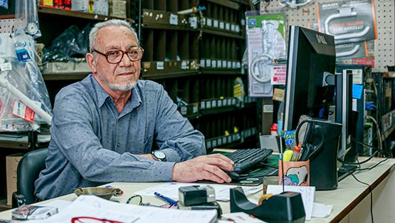 Hombre en su negocio frente a una computadora