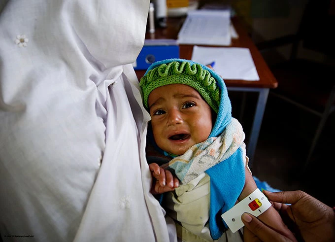 Faryal, nutrition assistant measures Arslan (1) mid-upper arm circumference (MUAC) at UNICEF supported nutrition center in Basic Health Unit (BHU) Mahabbat Abad, Mardan District, Khyber-Pakhtunkhwa province, Pakistan.