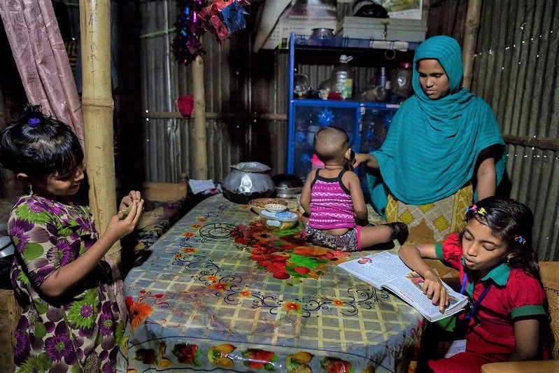 Sumaiya lit chez lui dans le bidonville de Sujat Nagar, au Bangladesh. © Dominic Chavez / Banque mondiale