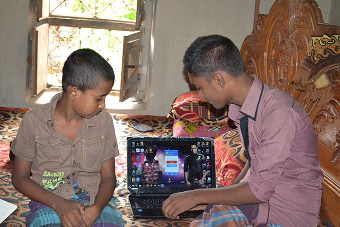 Children using a computer powered by solar energy