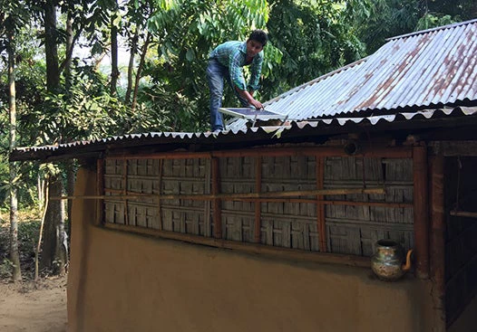 Installing a solar panel in Bangladesh. Xiaoyu Chang/World Bank