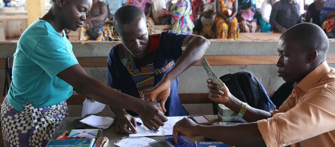 Men making cash transfer payments to women in Freetown, Sierra Leone. Photo © Dominic Chavez/World Bank