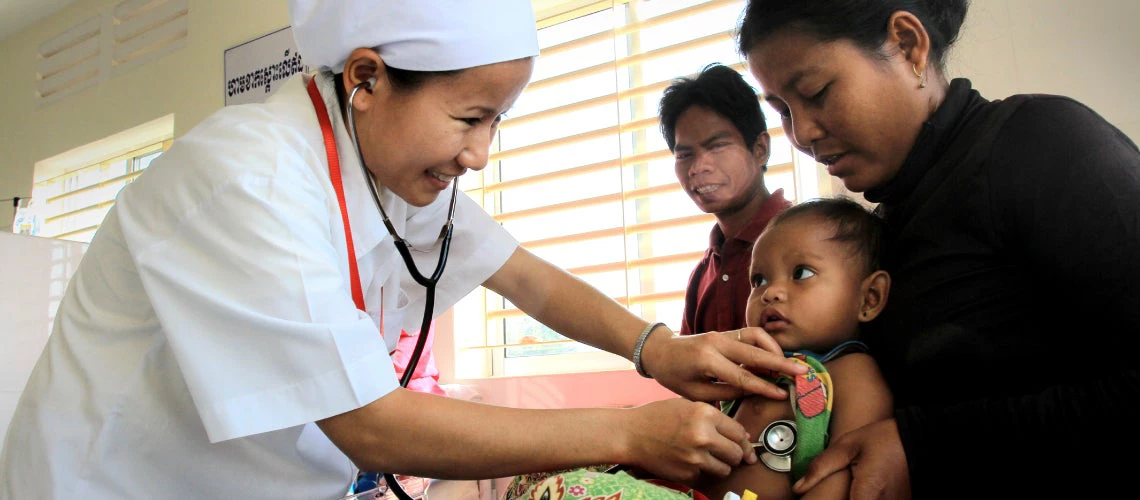 A trained medical staff listens to the hearbeat of an infant at 16 Makara hopsital in Preah Vihear, Cambodia. The hopsital is able to attract high quality medical staff because they are offered incentives through the Health Service Delivery Grant. Preah Vihear province, Cambodia. Photo: Chhor Sokunthea / World Bank