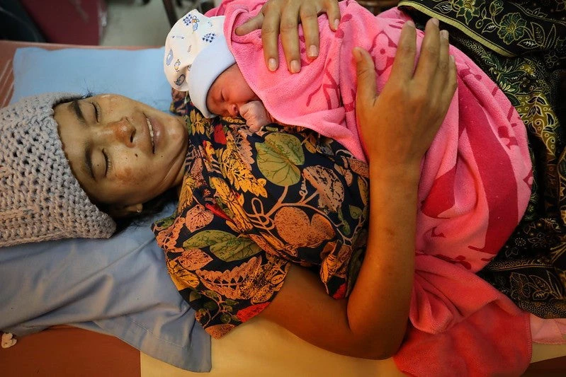 A mother holds her new-born son in the maternity ward of the Phnom Penh Municipal Hospital. 