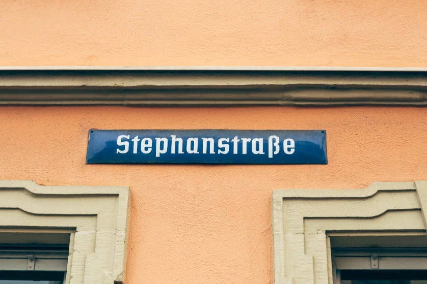 Letrero para el nombre de una calle en azul sobre una pared naranja con el nombre de Stephanstrasse en Wurzburg, Bavaria, Alemania.