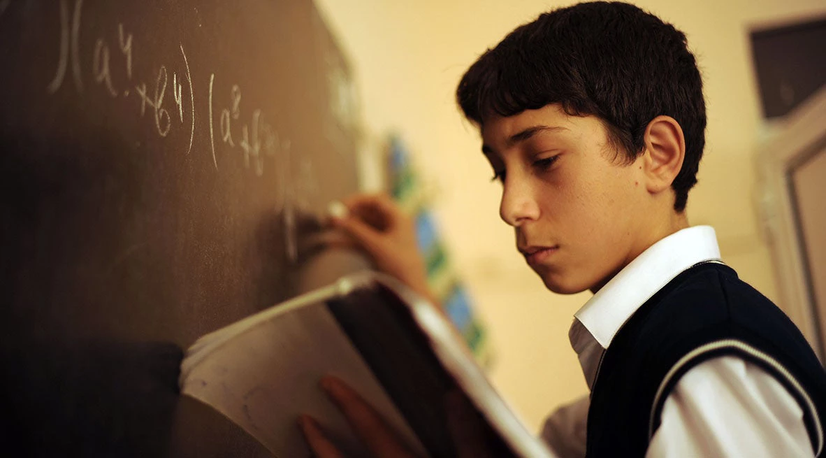 Ayyub Najarada, attends school at the Kalbajar School #56 in the Masazy settlement in Absheron Region. He is at the chalkboard, ready to answer questions.