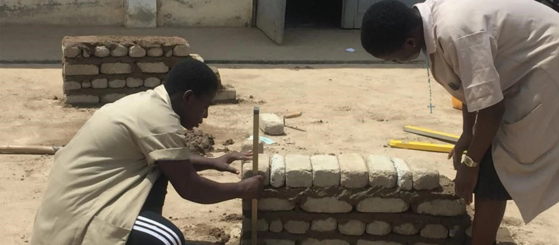 Two female students practicing brick laying