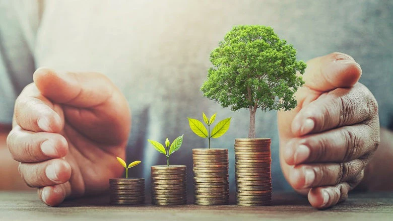 Hands surrounding coins to symbolize savings